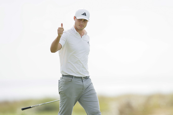 Ludvig Aberg of Sweden acknowledges fans after a chip in on the 14th green during the third round of The RSM Classic on the Seaside Course at Sea Island Resort on Nov. 18, 2023 in St Simons Island, Georgia.  [GETTY IMAGES]