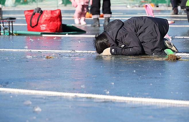 산천어 축제장을 찾은 참가자가 얼음 구멍에 얼굴을 묻은 채 낚시에 열중하고 있습니다. 집중해서 낚싯대를 드리우는 만큼 대어를 낚아야 할 텐데요.  한주형 기자
