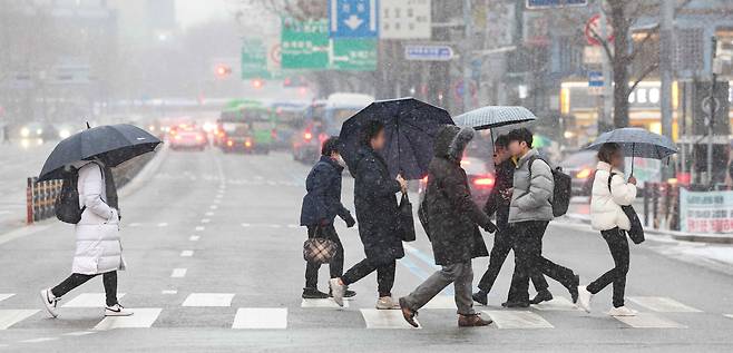 9일 오전 서울 중구 을지로입구역 인근에서 시민들이 눈을 맞으며 출근하고 있다./연합뉴스