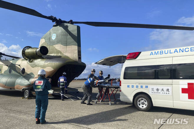 [고마쓰=AP/뉴시스]8일 일본 이시카와현 고마쓰에서 자위대 대원들이 지진 피해 지역에서 구조한 부상자를 구급차에 태우고 있다. 2024.01.09.