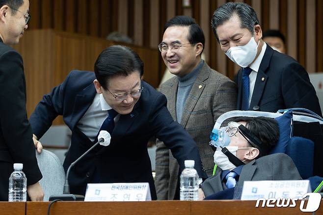 이재명 더불어민주당 대표가 3일 서울 여의도 국회에서 열린 확대간부회의에 참석하며 故 조연우 전국장애인위원장과 인사하고있다. 2023.2.3/뉴스1 ⓒ News1 유승관 기자