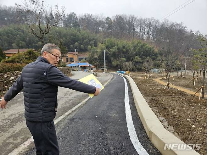 [보은=뉴시스] 안성수 기자 = 11일 충북 보은군 회남면 산수리 마을에서 양선석(76) 이장이 군에서 확장해 준 도로에 대해 설명하고 있다. 이 도로는 3년 전까지 차 한 대가 간신히 지나갈 정도로 좁아 주민들의 불편이 지속돼 왔다. 2024.1.11. hugahn@newsis.com