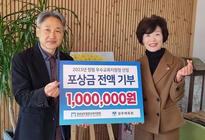 손경순(오른쪽) 밀양교육장이 아이들을 위해 뜻깊은 곳에 써 달라며 성금 100만원을 손성근 성우애육원 원장에게 기탁하고 있다. (사진=밀양교육지원청 제공) *재판매 및 DB 금지