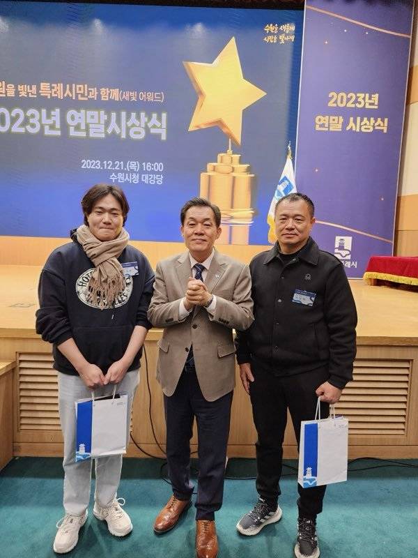 수원시로부터 감사장을 받고 이재준 수원시장과 기념촬영을 한 아버지 이상현 씨와 아들 이수연 씨. 최재호 기자 cjh1225@donga.com