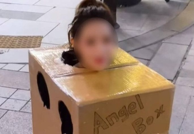 A woman wearing a bikini is seen in a box (Screenshot captured from an online community)