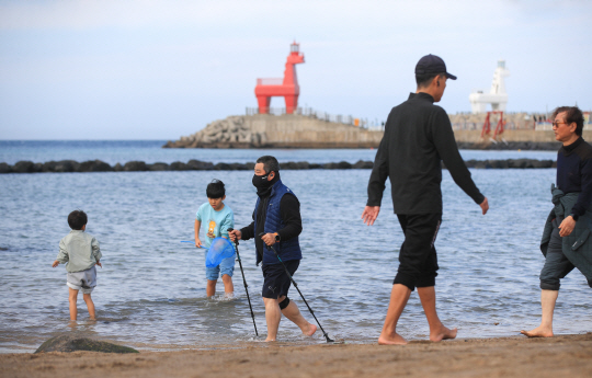 20도를 훌쩍 웃도는 등 포근한 날씨를 보인 지난해 12월 10일   제주시 이호해수욕장을 찾은 시민들이 맨발로 해변을 걸어가고 있다. 뉴시스