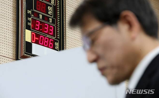 [과천=뉴시스] 황준선 기자 = 15일 오후 경기 과천시 중앙선거관리위원회에서 열린 '제22대 국회의원 선거 선거종합상황실 개소식'에서 선거장비 시연을 살펴보는 노태악 중앙선거관리위원장 너머로 총선 시계가 보이고 있다. (공동취재) 2024.01.15. hwang@newsis.com