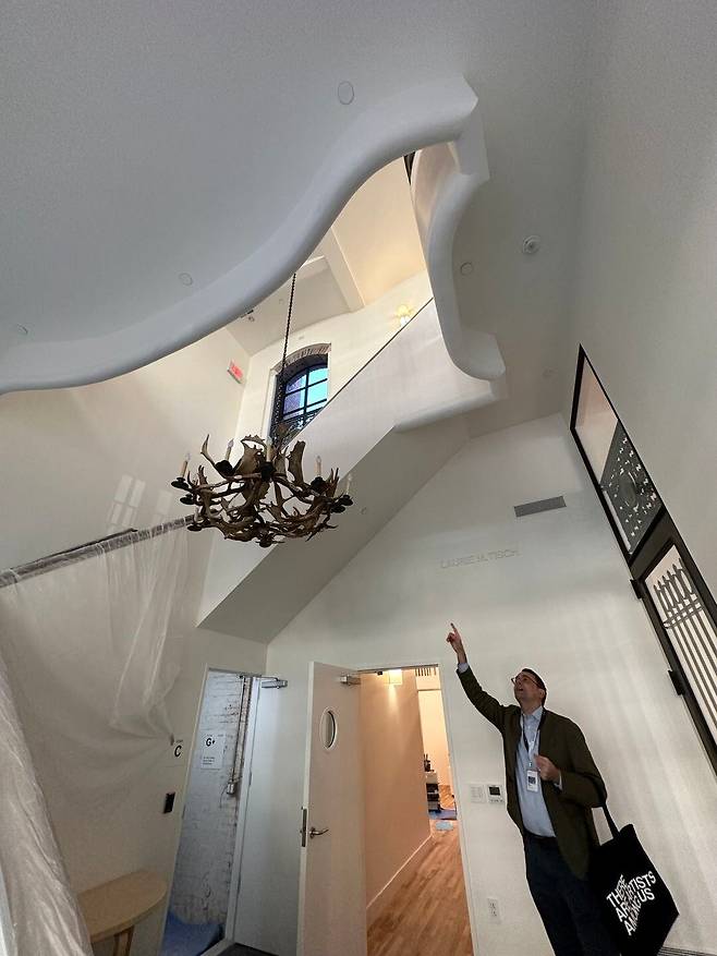 휘트니미술관 관계자가 로이 리히텐슈타인이 살던 건물에 달린 철제 샹들리에를 가리키고 있다. /윤주헌 특파원