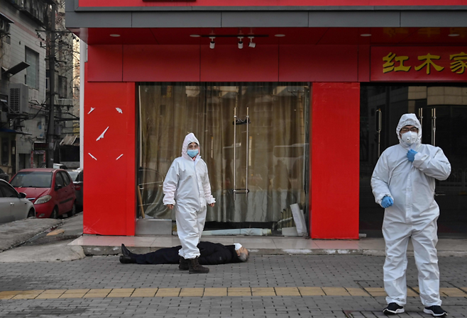 코로나19 창궐 직후인 2020년 1월 당시 봉쇄된 중국 우한 거리 모습. 시내 한 병원 근처 거리에 쓰러진 노인과 긴급 차량을 기다리는 중국 관료들. [사진출처=연합뉴스]