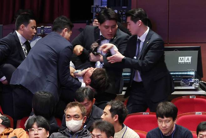 [전주=뉴시스] 전신 기자 = 강성희 진보당 의원이 18일 전주 덕진구 한국소리문화의전당 모악당에서 열린 전북특별자치도 출범식에서 윤석열 대통령이 참석자들과 인사하는 동안 경호원들에게 끌려 나가고 있다. 진보당측은 "강 의원이 윤 대통령과 악수하며 '국정기조를 바꾸지 않으면 국민들이 불행해집니다'라는 말을 건넨 순간 경호원들이 제지했다"고 주장했다. (대통령실통신사진기자단) 2024.01.18.