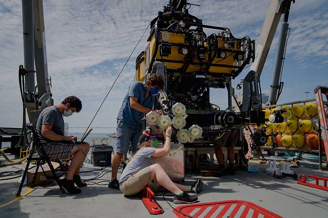 미국 로드 아일랜드대와 하버드대 연구진이 2021년 10월 탐사선 위에서 수중 탐사 로봇에 장착한 로봇팔을 점검하고 있다./미 슈미트 해양연구소