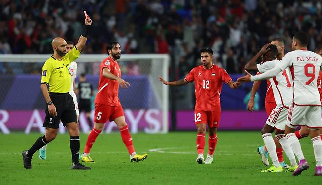 <yonhap photo-0903="">(알와크라=연합뉴스) 김도훈 기자 = 18일(현지시간) 카타르 알와크라 알자누브 스타디움 열린 2023 아시아축구연맹(AFC) 아시안컵 조별리그 C조 팔레스타인 대 아랍에미리트 경기. 주심이 비디오 판독 끝에 페널티 박스에서 파울을 범한 알함마디에게 레드카드를 주고 있다.&nbsp;</yonhap>