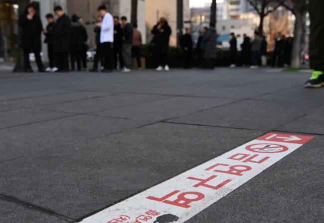 무늬만 금연구역… 19일 서울 도심 금연구역에서 흡연자들이 담배를 피우고 있다. 주변에 가까운 흡연구역이 없어 이 일대 흡연자들이 몰리면서 보행자들이 불편을 겪고 있다. 윤성호 기자