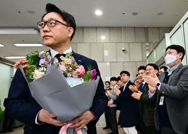 김진욱 고위공직자범죄수사처장이 19일 오전 정부과천청사 공수처에서 열린 이임식을 마친 뒤 건물을 나서며 직원들로부터 꽃다발을 받고 있다. 연합뉴스