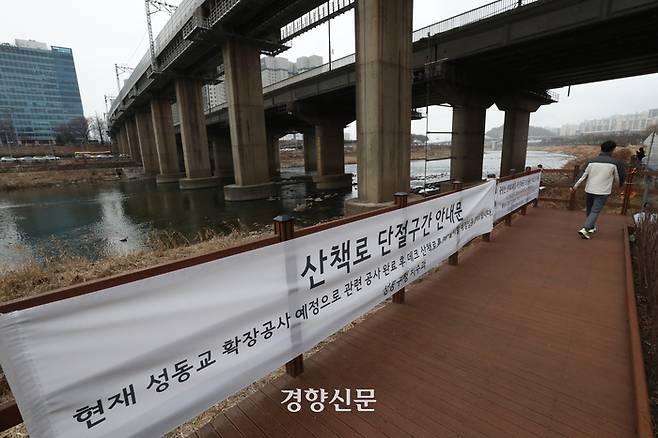 서울 성동구 중랑천변에 설치된 산책로에 각종 공사 안내문이 걸려 있다.