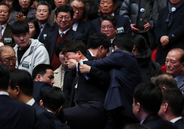 ▲진보당 강성희 의원이 18일 전주시 덕진구 한국소리문화의전당 모악당에서 열린 전북특별자치도 출범식에서 윤석열 대통령이 입장하며 참석자들과 악수하는 동안 경호원들에게 제지당해 끌려나가고 있다. 진보당측은 "강 의원이 윤 대통령과 악수하며 '국정기조를 바꾸지 않으면 국민들이 불행해집니다'라는 말을 건넨 순간 경호원들이 제지했다"고 주장했다. ⓒ연합뉴스