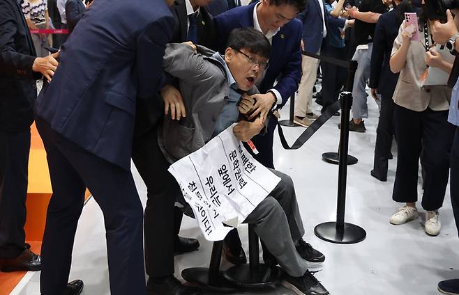 지난 14일 서울 강남구 코엑스에서 개막한 서울국제도서전에서 송경동 시인이 문화예술계 블랙리스트 작성 논란이 있는 오정희 소설가의 2023 서울국제도서전 홍보대사 임명에 항의하며 시위를 하고 있다.  연합뉴스