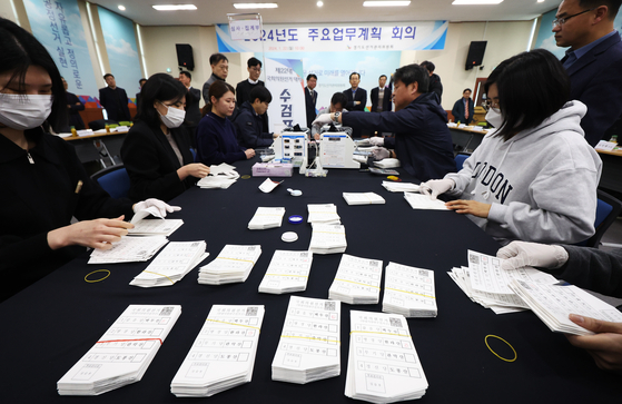 The Gyeonggi office of the National Election Commission demonstrates the manual vote counting process at its Suwon office on Monday. The election commission last month announced its plan to replace electronic vote counting with manual counting for the upcoming general election in April. Additionally, a 24-hour surveillance camera will be installed at the facility that will store early votes. The decision to revert to manual vote counting stems from concerns raised by the National Intelligence Service, which identified vulnerabilities in the electronic vote counting system. [YONHAP]