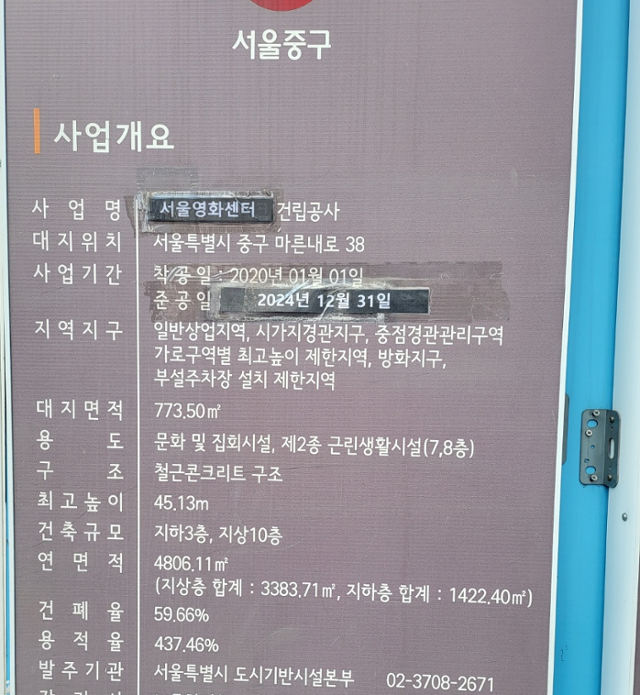 22일 오후 서울 중구 충무로에 위치한 서울영화센터 공사현장에서 사업 준공일이 '2024년 12월 31일'로 적힌 검은색 종이로 바꿔서 붙여져 있다.