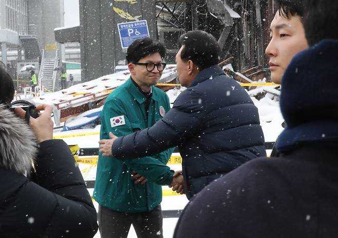 윤석열 대통령이 23일 충남 서천군 서천읍 서천특화시장 화재 현장에서 국민의힘 한동훈 비상대책위원장과 만나 포옹하고 있다.  <연합뉴스,>