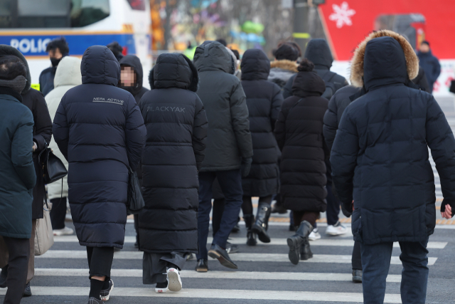 23일 오전 두꺼운 복장의 시민들이 서울 광화문 사거리를 지나고 있다. 연합뉴스