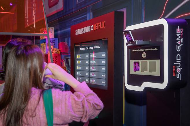 Visitors take photos with the Samsung Galaxy Z Flip5 at the "Squid Game: The Trials," an immersive experience program in Los Angeles. (Samsung Electronics)