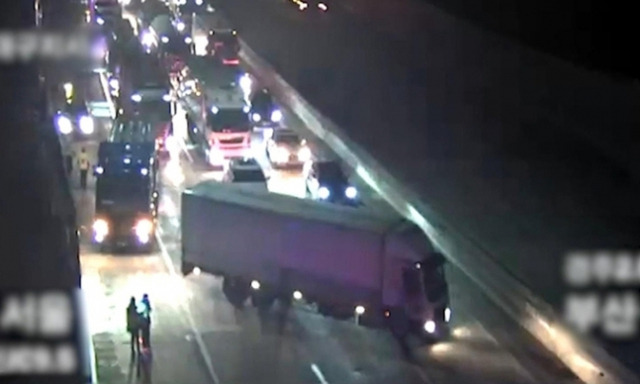 Two semi-trailer trucks form a roadblock on the Gyeongbu Expressway to prevent accidents on Tuesday. (Gyeongbuk Provincial Police Agency)