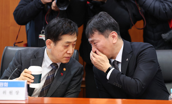 Financial Services Commission Chairman Kim Joo-hyun, left, and Financial Supervisory Service Gov. Lee Bok-hyun speak during a meeting with CEOs of local brokerage companies in western Seoul on Thursday. [YONHAP]