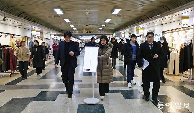 23일 대전 중구 중앙로 지하상가에서 진행된 실내 내비게이션 시연회에서 관계자들이 애플리케이션(앱) ‘대전 길 알림이(위쪽 사진)’를 보고 길을 찾아가고 있다. 김태영 기자 live@donga.com