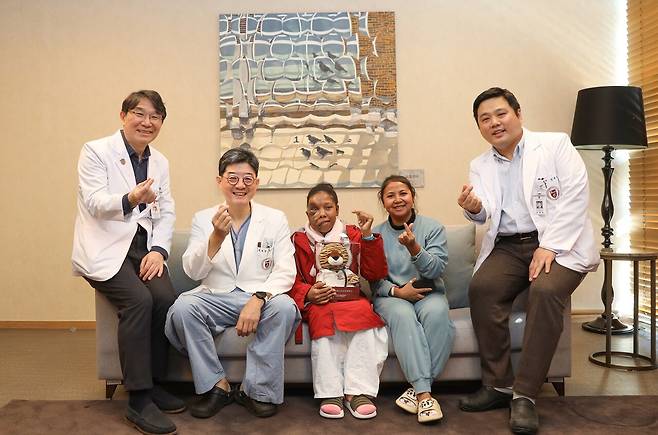 Rasoanandrasana Vaosolo, a neurofibroma patient from the Republic of Madagascar, poses with surgeons from the Korea University Anam Hospital. (Korea University Anam Hospital)