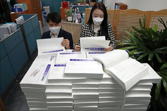 국회사무처 관계자들이 관보를 통해 공개된 재산공개 대상자 정기 재산변동사항 신고내역을 살펴보고 있다. [중앙포토]