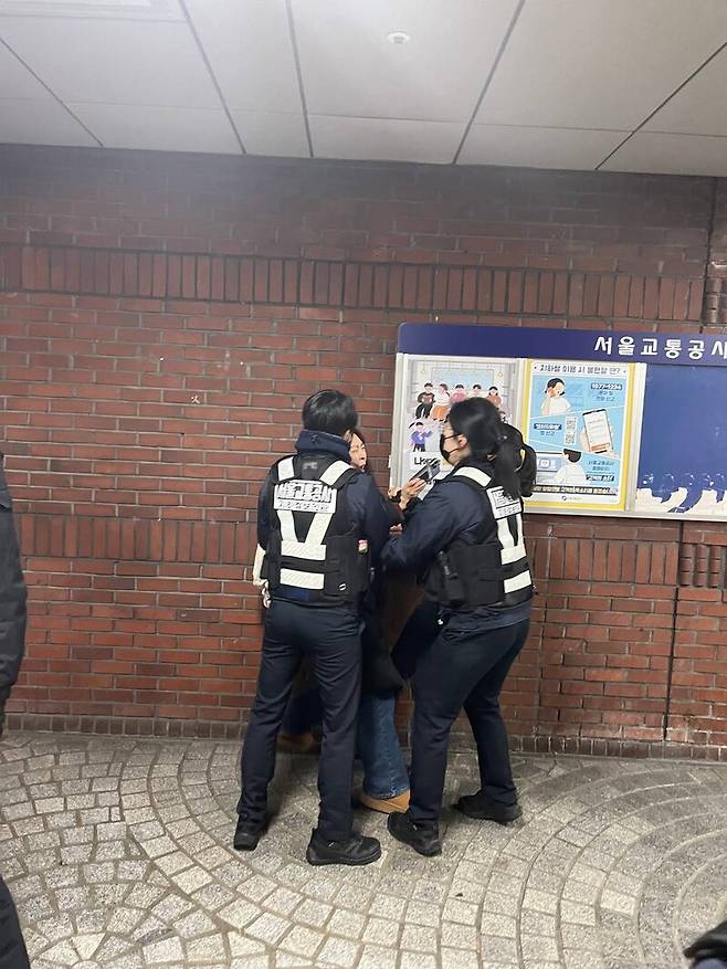 ▲여미애 레디앙 기자가 지난 24일 오후 서울지하철 1·2호선 시청역에서 전장연이 주최한 '권리중심공공일자리 노동자 해고 철회 및 복직 투쟁' 기자회견에 앞서 공사에 의해 강제 퇴거를 당하는 모습. 사진=여미애 기자 제공