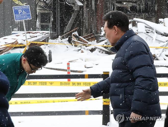 (서울=연합뉴스) 배재만 기자 = 국민의힘 한동훈 비상대책위원장이 23일 충남 서천군 서천읍 서천특화시장 화재 현장에서 윤석열 대통령을 만나 허리숙여 인사하고 있다. 2024.1.23 scoop@yna.co.kr 연합뉴스