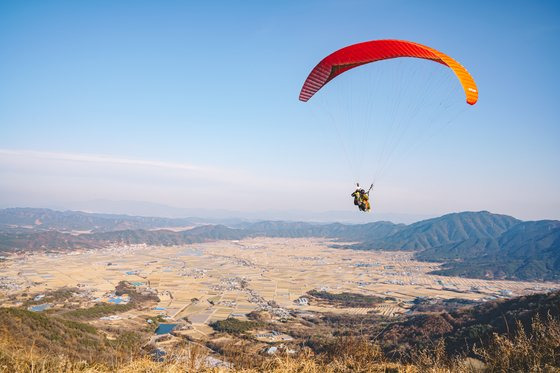 경남 합천군 초계면과 적중면에 걸쳐 있는 '적중-초계 분지'. 5만 년 전 한반도에 운석이 떨어져 생긴 '운석충돌구'가 내려다 보이는 대암산에서 한 시민이 패러글라이딩을 하고 있다. 사진 합천군