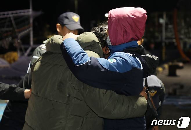 서귀포 해상 어선 침몰 사고 현장에서 구조된 인도네시아 국적 선원 A씨(23·왼쪽)가 28일 오전 제주 서귀포시 성산항에 도착한 직후 마중나와 있던 친구의 어깨에 기대며 안도의 한숨을 내쉬고 있다.  2024.1.28/뉴스1 ⓒ News1 오미란 기자