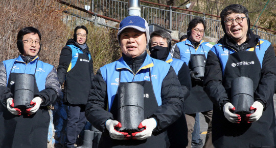 진옥동(사진 가운데) 신한금융그룹 회장, 정지호(맨 왼쪽) 신한파트너스 사장, 이동현(맨 오른쪽) 신한벤처투자 사장 등 봉사자들이 25일 연탄나눔 봉사활동을 하고 있다. <신한금융 제공>