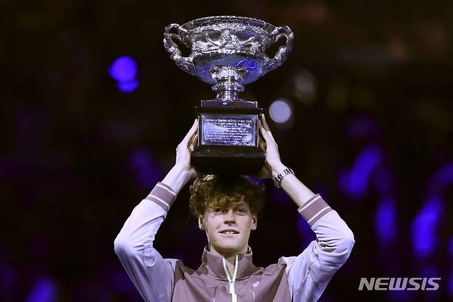 Jannik Sinner of Italy holds the Norman Brookes Challenge Cup aloft after defeating Daniil Medvedev of Russia in the men's singles final at the Australian Open tennis championships at Melbourne Park, in Melbourne, Australia, Sunday, Jan. 28, 2024. (AP Photo/Asanka Brendon Ratnayake)