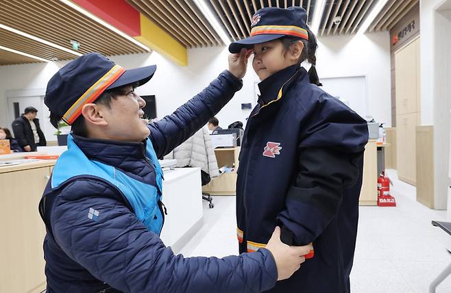 윤철민 집배원이 자신이 근무하는 강원 양양 현남우체국에 체험 온 딸 윤시하에게 집배원 모자를 씌우고 있다.