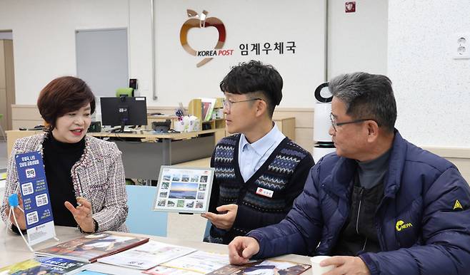 심상환 강원 정선 임계우체국장이 새롭게 단장한 우체국을 찾은 주민들과 정선을 소개하는 우표를 보며 지역의 현안에 대해 대화하며 차담을 하고 있다.