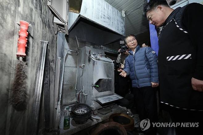 이정식 고용노동부 장관(왼쪽)이 29일 중소영세기업 중대재해처벌법 적용 관련 사업장 순회로 서울 중구 명동의 한 음식점을 방문해 숯가마를 살펴보고 있다. 연합뉴스