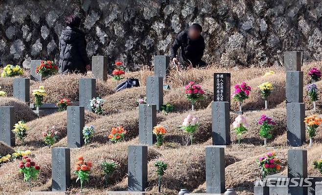 [부산=뉴시스] 하경민 기자 = 설 연휴를 열흘 정도 앞둔 28일 부산 금정구 영락공원을 찾은 한 가족이 벌초 및 성묘를 하고 있다. 2024.01.28. yulnetphoto@newsis.com