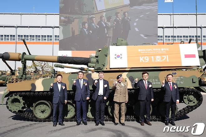 19일 한화디펜스 창원 1사업장에서 열린 폴란드 수출 K9 자주포 초도물량 24문에 대한 출하식에서 박완수 경남도지사(왼쪽부터)와 곽종우 한화디펜스 부사장, 피오트르 오스타셰프스키 주한 폴란드 대사, 마치에이 야브원스키 폴란드 육군사령관, 엄동환 방위사업청장, 홍남표 창원시장이 K9 자주포 1호기에 장비 서명 기념 촬영을 하고 있다. (한화디펜스 제공) 2022.10.19/뉴스1