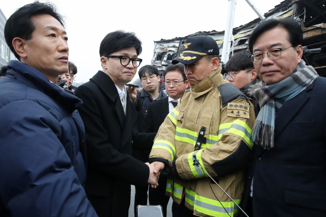 한동훈(앞줄 왼쪽 두 번째) 국민의힘 비상대책위원장이 1일 경북 문경시 육가공 업체 공장 화재 현장을 찾아 배종혁(〃 세 번째) 문경소방서장을 위로하고 있다. 연합뉴스