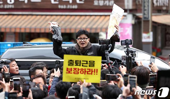 한동훈 국민의힘 비상대책위원장이 설 명절 연휴를 나흘 앞둔 5일 서울 동대문구 청량리 청과물시장·경동시장을 방문해 구매한 상품을 들어보이며 시민들과 인사를 나누고 있다. (공동취재) 2024.2.5/뉴스1 ⓒ News1 임세영 기자