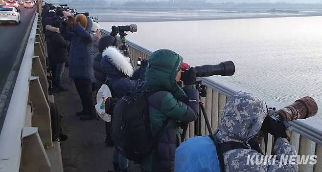 한겨울 매서운 강바람을 견디며 수십 명의 사진가들이 초망원 렌즈를 남산방향을 향해 초점을 맞추고 아침 해가 솟아오르길 기다리고 있다.