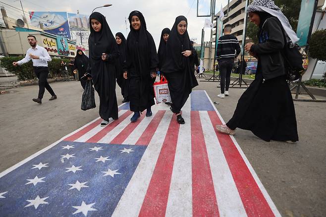 4일(현지시간) 이라크 시아파 무슬림 순례자들이 이라크 바그다드 북부 카드히미야 지역에서 그의 죽음을 기념하기 위해 이맘 무사 알-카드힘의 사당으로 행진하면서 미국과 이스라엘 국기를 밟고 있다. [AFP]
