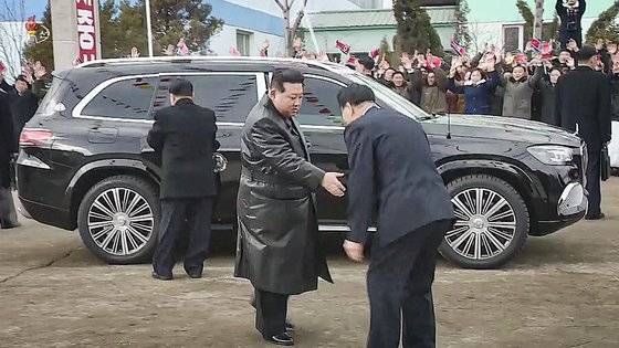 북한이 지난달 15일 공개한 기록영화에서 김정은 국무위원장이 신형 벤츠 마이바흐 SUV에서 내려 영접을 받고 있다. [연합뉴스]