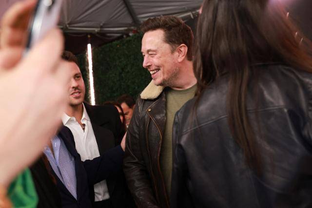 일론 머스크 테슬라 최고경영자(CEO)가 지난 3일(현지시간) 미국 캘리포니아 로스앤젤레스 리젠시 브루인 극장에서 열렸던 '롤라' 시사회 참석해 환담을 나누고 있다. 로이터 연합뉴스