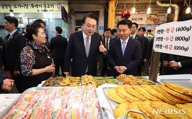 [서울=뉴시스] 조수정 기자 = 윤석열 대통령이 설 연휴를 하루 앞둔 8일 서울 광진구 중곡제일시장을 방문해 전집 상인과 대화하며 엄지를 치켜세우고 있다. 2024.02.08. chocrystal@newsis.com