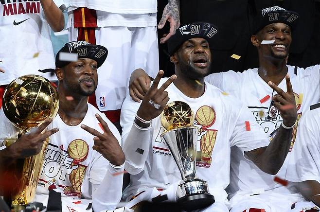 마이애미 히트의 드웨인 웨이드(왼쪽부터), 르브론 제임스, 크리스 보시가 2013년 6월20일 NBA 결승전에서 샌안토니오 스퍼스를 꺾고 우승한 뒤 트로피를 들고 기념사진을 찍고 있다. 제임스의 마이애미는 ‘슈퍼팀 시대’를 열어젖힌 개척자라고 평할 만하다. EPA 연합뉴스